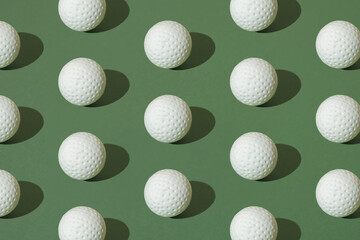 White golf ball on a green pastel background. Pattern.