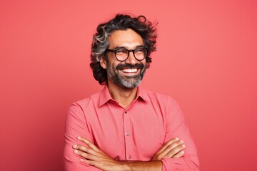 Portrait of a smiling man in glasses on a red background.