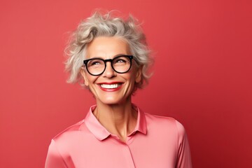Portrait of happy senior woman in eyeglasses on red background - obrazy, fototapety, plakaty