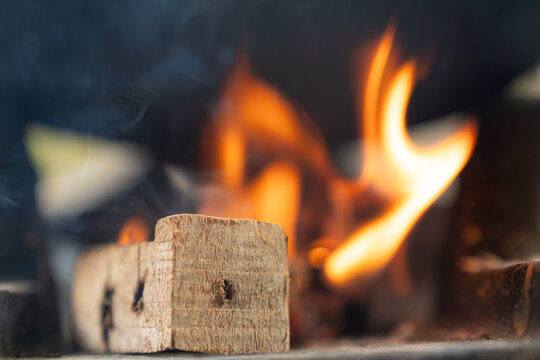 Close-up photography capturing the mesmerizing flames in firewood, revealing intricate and infinite shapes. The vivid orange flames against the black backdrop create captivating textures.