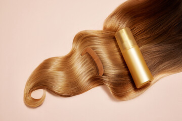 Ply of shiny, wavy, blonde hair with wooden brush and hair product, conditioner, mask over light background. Concept of hair care, organic products, natural beauty, cosmetics. Ad. Poster.