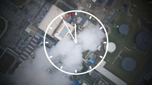 Time to reduce CO2 emissions, clock overlay with a smoking chimney background