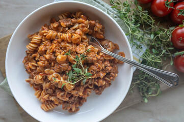 Creamy beef pasta on a plate isolated on light background from above. Homemade cooked