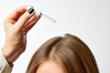 Cropped image of female head over white background. Using special hair products for growth, serum, oil, mask. Concept of hair care, organic products, natural beauty, cosmetics. Ad. Poster.