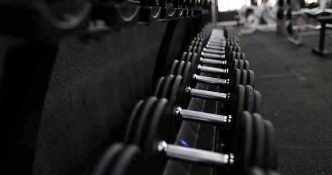Rack with dumbbells in gym. Camera movement on dumbbell rack