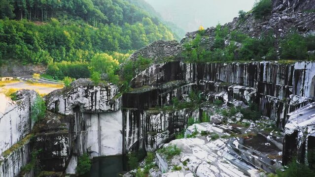 Drone fly down and pan in abandoned white marble quarry in Carrara