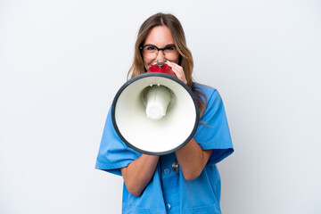 Young surgeon doctor woman isolated on blue background shouting through a megaphone