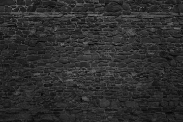Old black stone wall texture. Dark background