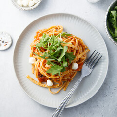 Pasta with tomatoes, mozzarella and arugula