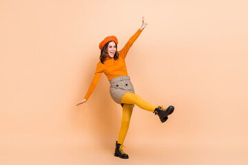 Fototapeta na wymiar Full length photo of cheerful lady wear orange clothes good mood look empty space celebrate big sale isolated on beige color background