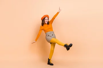 Fototapete Musikladen Full length photo of cheerful lady wear orange clothes good mood look empty space celebrate big sale isolated on beige color background