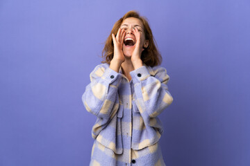 Young Georgian woman isolated on purple background shouting and announcing something