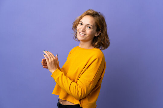Young Georgian woman isolated on purple background applauding
