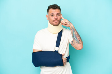 Young caucasian man wearing a sling  and neck lace isolated on blue background thinking an idea