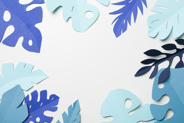 Fototapeta na wymiar Paper blue tropical leaves on a light background