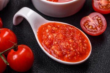 Delicious hot spicy red sauce with salt and spices in a ceramic bowl