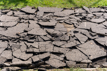 broken, cracked asphalt road. fragments of asphalt.