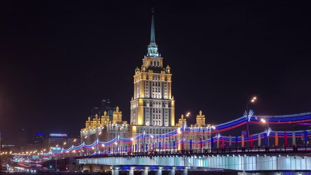 Winter Night Timelapse Hyperlapse of Hotel Ukraine, One of the Seven Sister Skyscrapers in Moscow, Russia. Iconic Landmark from Stalin's Era, Illuminated Cityscape with Moscow River Bridge