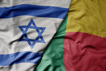 big waving national colorful flag of israel and national flag of benin .