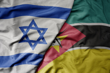 big waving national colorful flag of israel and national flag of mozambique .