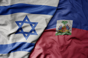 big waving national colorful flag of israel and national flag of haiti .