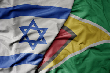 big waving national colorful flag of israel and national flag of guyana .