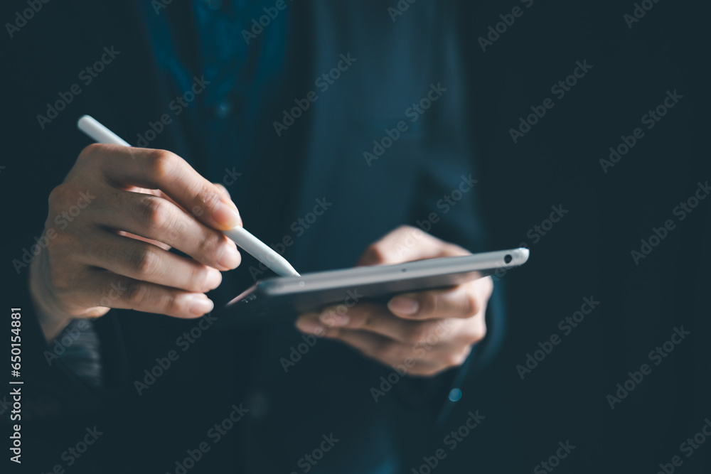 Poster concept of using technology in communication.close-up a businessman working on his teblet in the off
