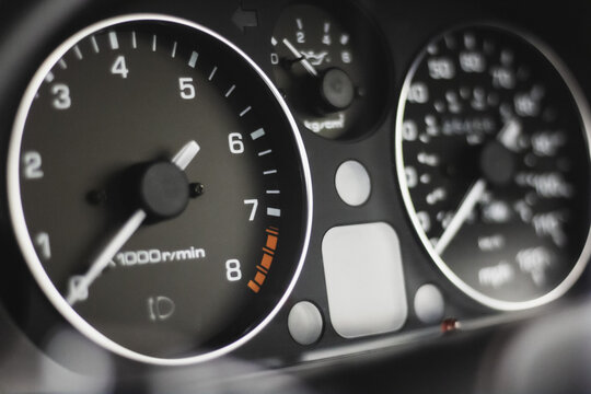 Close up photo of modern classic car gauges showing speedometer and tachometer