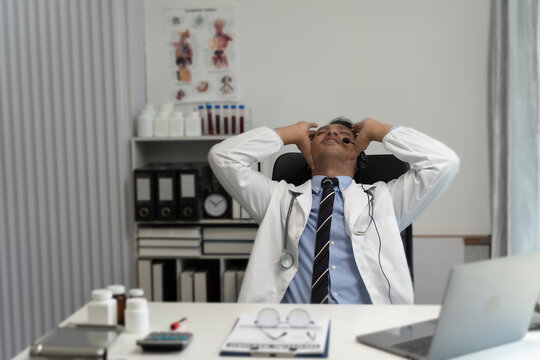 Stressed doctor sitting stress headache about work in hospital medical problem practitioner unhappy, desperate, exhausted, frustrated, headache health care healthcare tired trouble at the workplace