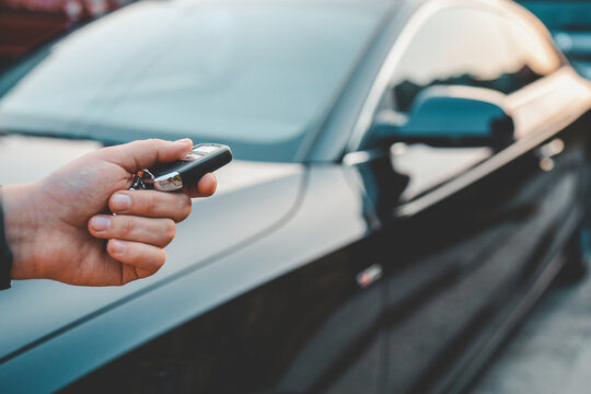 Key in hand against the background of a car
