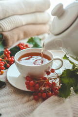 Cup of tea in autumn composition with viburnum