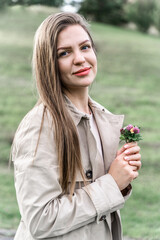 Portrait of a woman outdoors. Long-haired girl with flowers