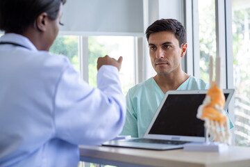 Obraz premium Female doctor and male patient Discuss and give advice about wrist and arm pain among patients in the hospital.