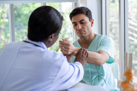 Female doctor and male patient Discuss and give advice about wrist and arm pain among patients in the hospital.