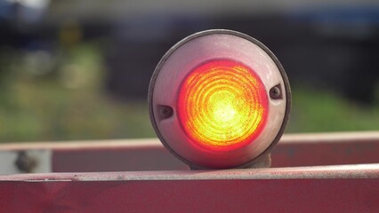 Flashing Red Signal Light on Railway Level Crossing Barrier Close-Up