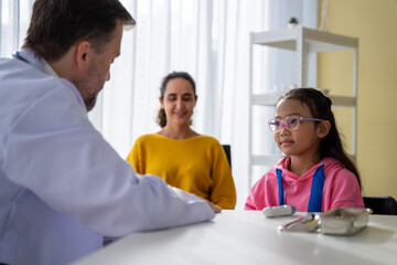 Obraz premium Male doctor and girl young patient Talk and give advice about your illness at the hospital.