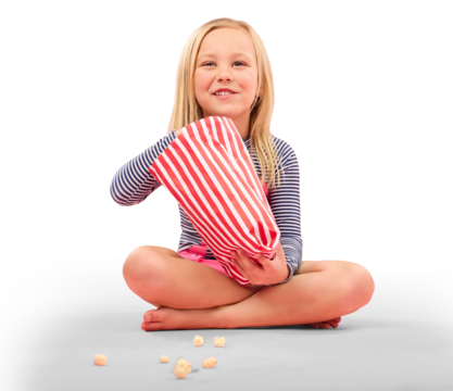 Happy little girl, sitting and eating popcorn, snack or luxury for movie isolated on a transparent PNG background. Female person, child or hungry kid smile with food in paper bag or watching TV
