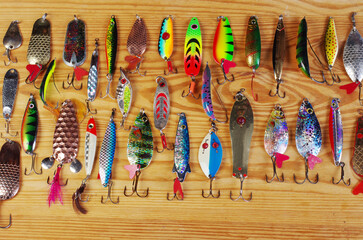 Set of metal spinning lures on a wooden texture background.