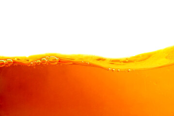 Orange liquid splash isolated on white background. Close up of orange liquid. - obrazy, fototapety, plakaty