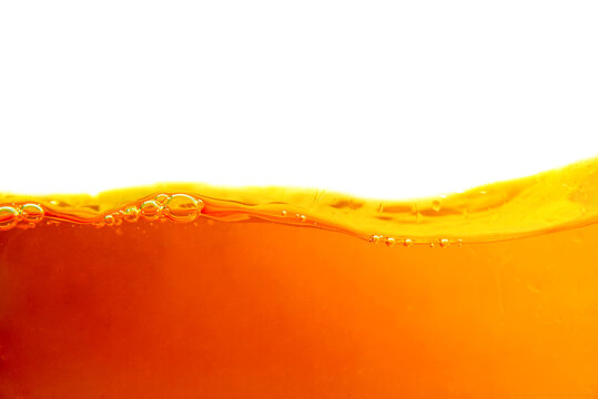 Orange liquid splash isolated on white background. Close up of orange liquid.