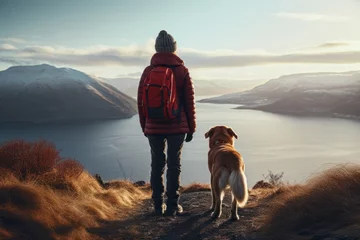 Gordijnen A person standing on a hill with their loyal dog by their side. This image captures the beauty of nature and the bond between humans and animals. Perfect for outdoor adventure, friendship, and pet-rel © Fotograf
