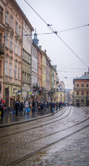 Fototapeta na wymiar Rainy autumn day in Lviv, Ukraine. Wet day, cold autumn. Old town, main square, gloomy day, 