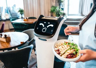 Robot waiter serve food at modern restaurant table.Offering innovation futuristic high-tech...