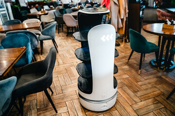 Robot waiter serve food at modern restaurant table.Offering innovation futuristic high-tech automated dining experience.Bringing,delivery automation order to customer.Digital robotic AI smart service
