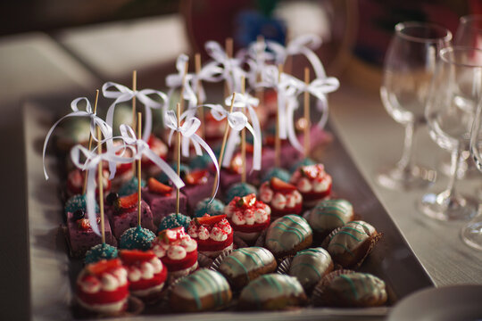 Delicious cakes macarons on candybar Wedding Event. A variety of delicious desserts, cakes with cream, berries, whipped cream, marshmallows, festive decor, sweet bar, a treat.