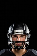 American football player with ball wearing helmet and protective shields isolated over black background, close up