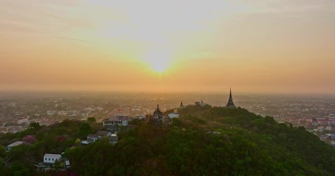 aerial view The rays of the sun shine atop the hilltop castle at Phetchaburi Thailand..Built by King Rama IV in 1859 The first palace in Thailand to be build on a mountain. .golden sky background.
