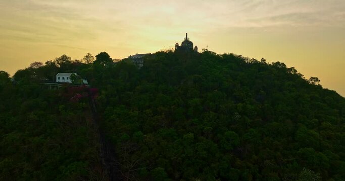 aerial view The rays of the sun shine atop the hilltop castle at Phetchaburi Thailand..Built by King Rama IV in 1859 The first palace in Thailand to be build on a mountain. .golden sky background.