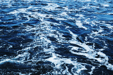 Ocean wave background. Bubble water backdrop. Turbulent sea texture. Messy water flow. Depth of the sea. Water foam surface backdrop. Rapid river flow.