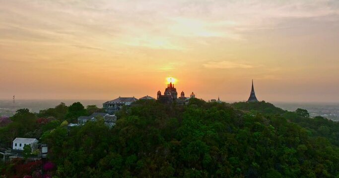 aerial view The rays of the sun shine atop the hilltop castle at Phetchaburi Thailand..Built by King Rama IV in 1859 The first palace in Thailand to be build on a mountain. .golden sky background.